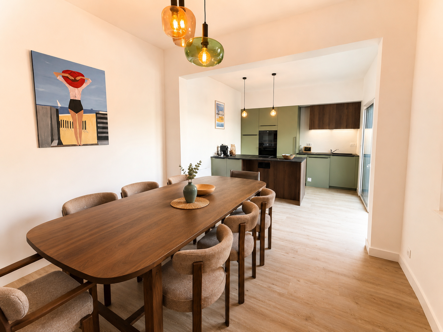 Salle à manger avec grande table en bois et cuisine ouverte